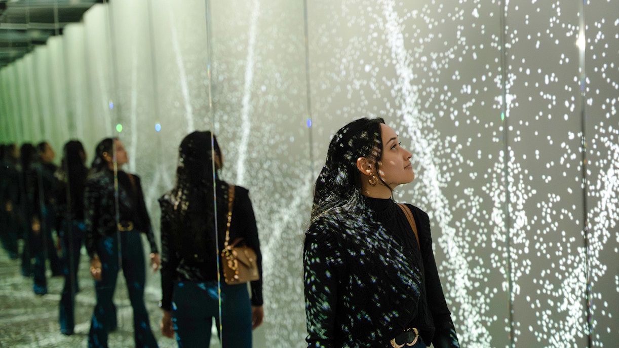 Guest exploring mirrored light display at World of Illusion, Dublin.
