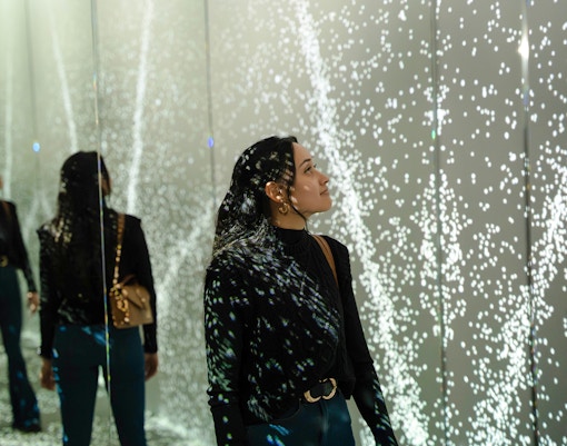 Guest exploring mirrored light display at World of Illusion, Dublin.