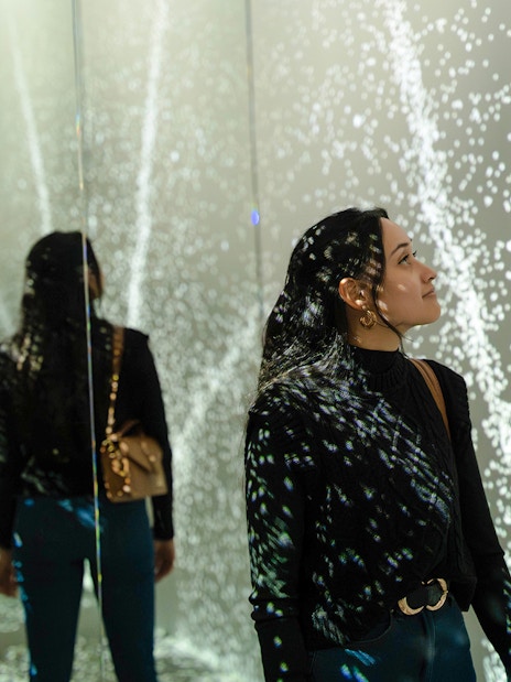 Guest exploring mirrored light display at World of Illusion, Dublin.