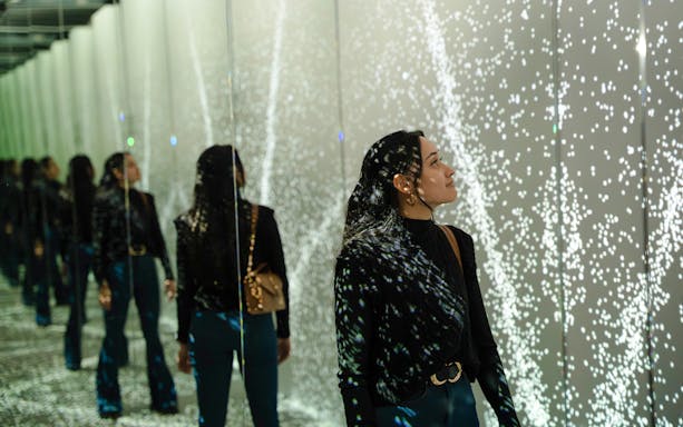 Guest exploring mirrored light display at World of Illusion, Dublin.