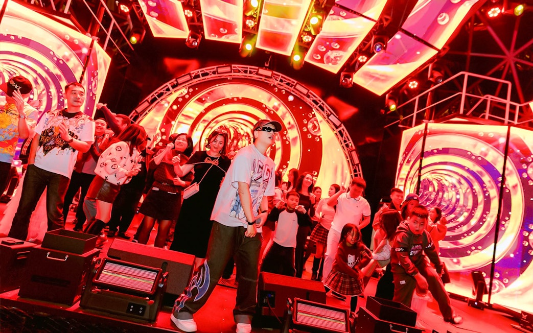 Guests enjoying a vibrant night show on a Dolphin cruise with colorful lights and music.