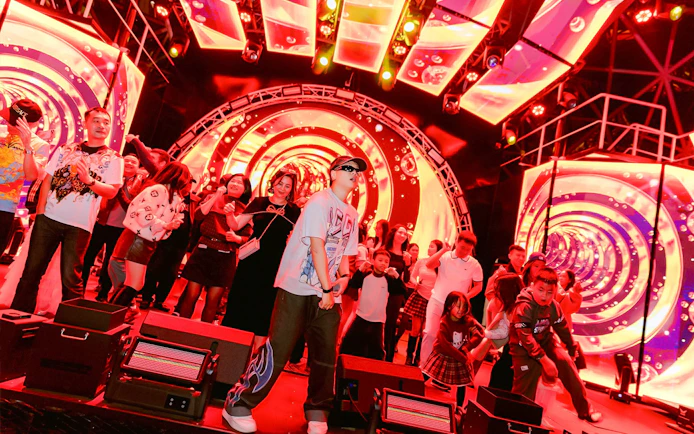 Guests enjoying a vibrant night show on a Dolphin cruise with colorful lights and music.