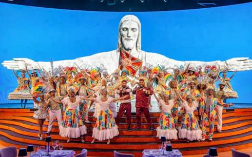 Performers in colorful costumes on stage at Roxy Dinner Show, Rio de Janeiro.