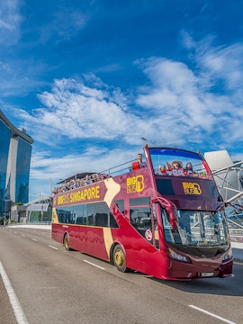 Open-top Big Bus Singapore tour passing Marina Bay Sands.