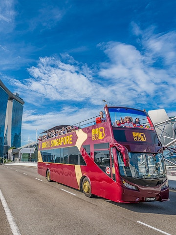 Open-top Big Bus Singapore tour passing Marina Bay Sands.