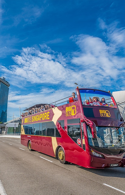 Open-top Big Bus Singapore tour passing Marina Bay Sands.