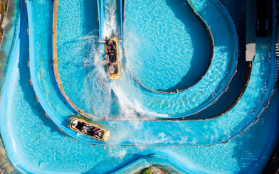 Water slide at Beto Carrero World with people riding in a raft on a winding blue track.