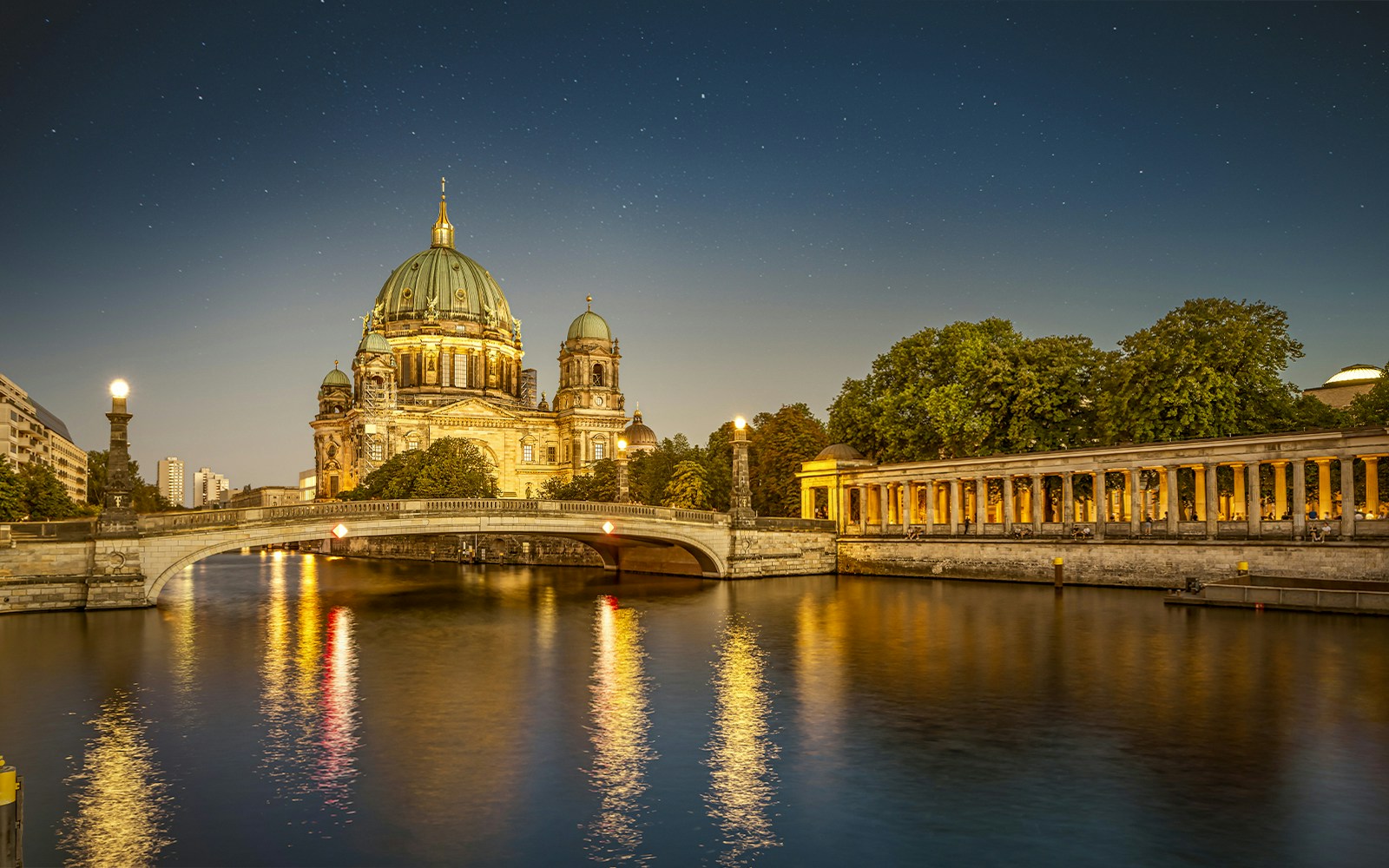 Evening boat tour on the Spree River with city lights in Berlin.