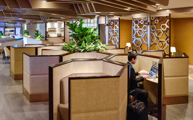 Cubicles in Plaza Premium Lounge at Singapore airport with a person working on a laptop.