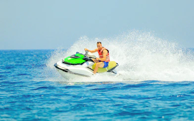 Tourist riding a jetski on open water.