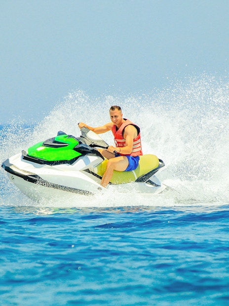 Tourist riding a jetski on open water.