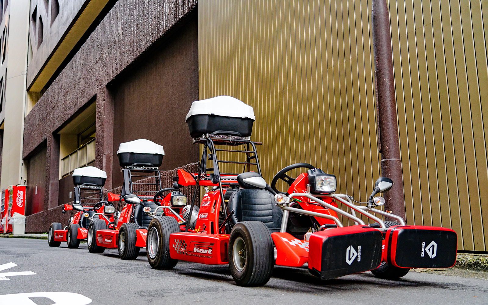 Red go-karts lined up on a street in Akihabara, Tokyo, ready for a driving experience.