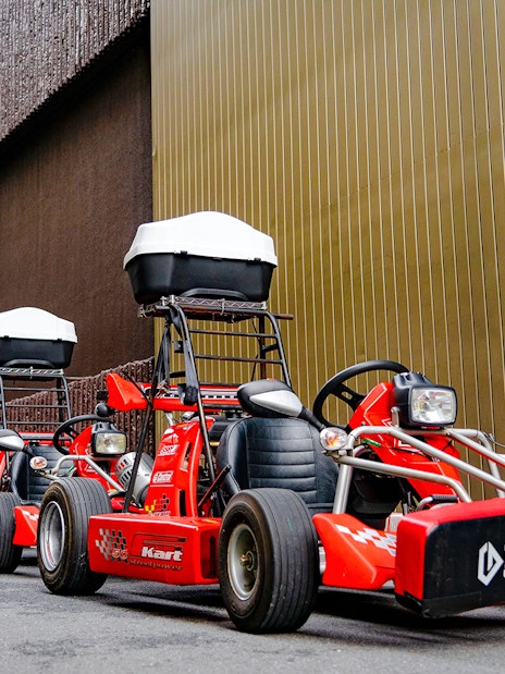 Red go-karts lined up on a street in Akihabara, Tokyo, ready for a driving experience.