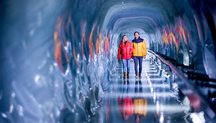 Couple walking through the Ice Palace at Jungfraujoch, Switzerland.
