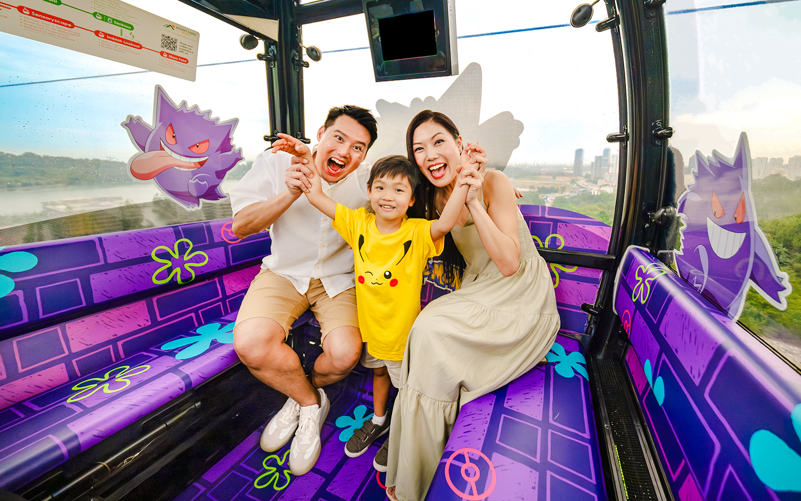 Family enjoying a Pokemon-themed cable car ride on Sentosa Island, Singapore.