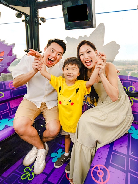 Family enjoying a Pokemon-themed cable car ride on Sentosa Island, Singapore.