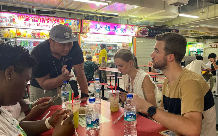 Group enjoying local food at a hawker center during Bike and Bites Food Tour.