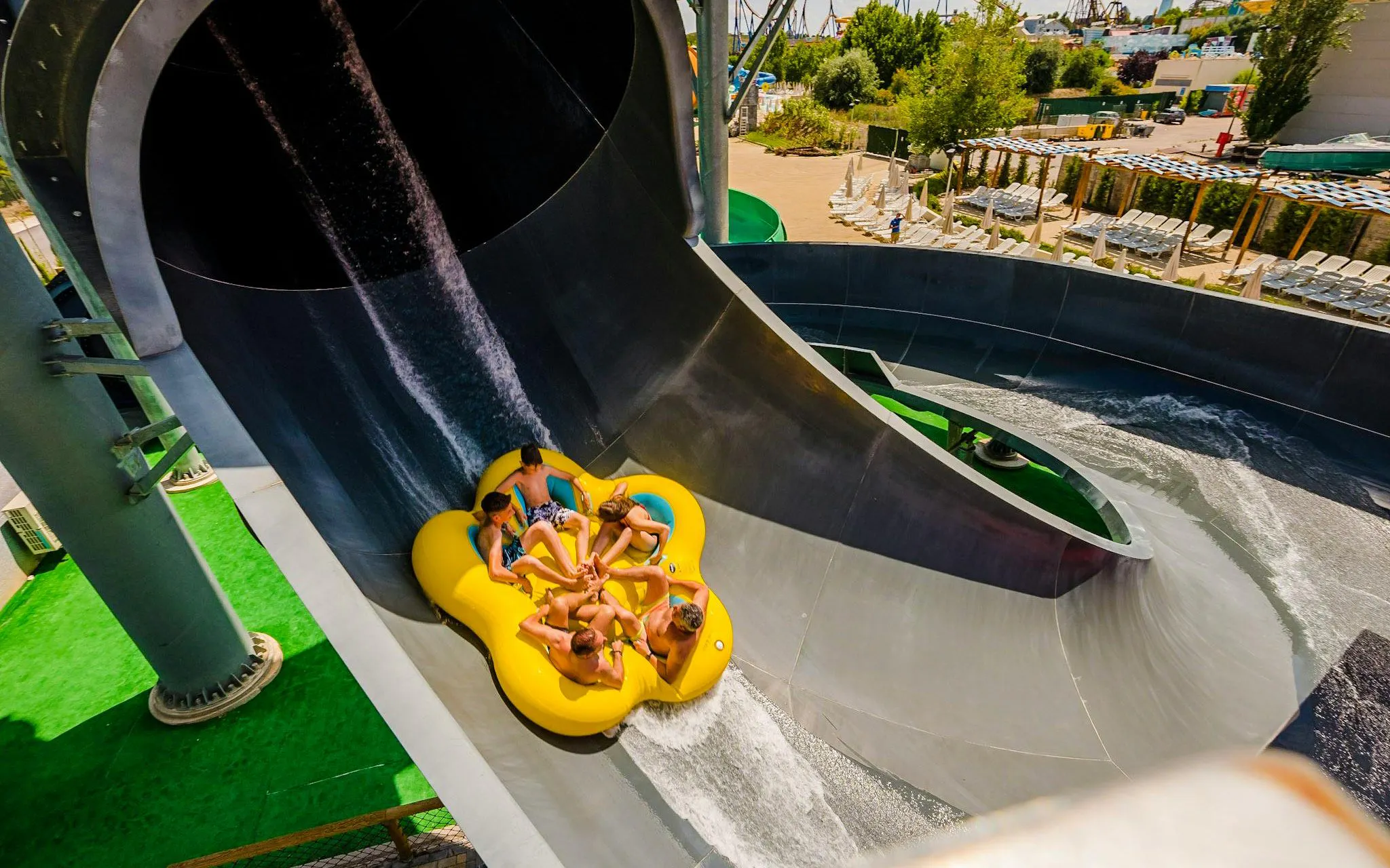 Group on a yellow raft sliding down a water slide at Parque Warner Beach.
