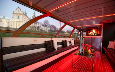 Interior of the Vistula River Cruise catamaran in Krakow with seating and a view of a church.