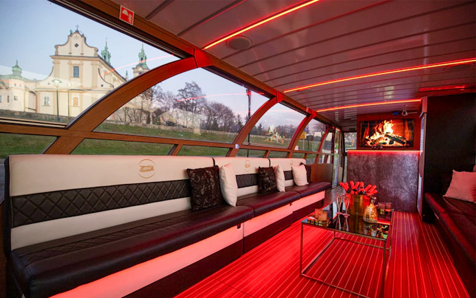 Interior of the Vistula River Cruise catamaran in Krakow with seating and a view of a church.