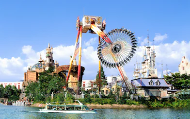 Lotte World amusement park ride with castle backdrop and boat on lake.