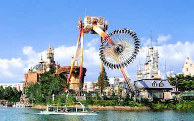 Lotte World amusement park ride with castle backdrop and boat on lake.