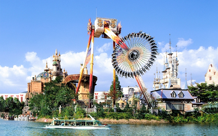 Lotte World amusement park ride with castle backdrop and boat on lake.