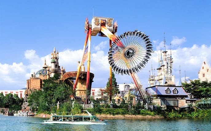 Lotte World amusement park ride with castle backdrop and boat on lake.