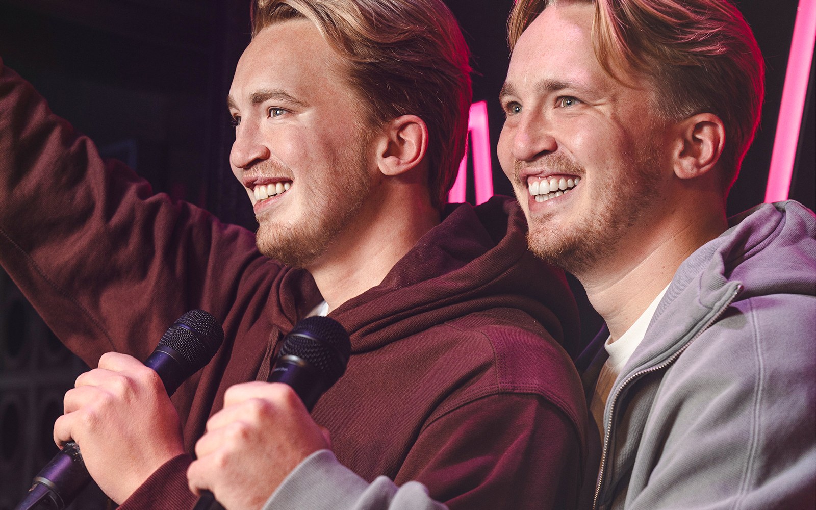 Two figures holding microphones at Madame Tussauds Amsterdam.