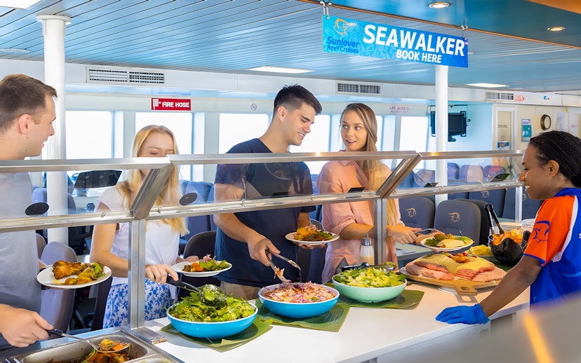 Tourists serving themselves at a buffet on Moore Reef Day Tour, Great Barrier Reef.