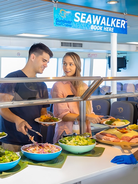 Tourists serving themselves at a buffet on Moore Reef Day Tour, Great Barrier Reef.