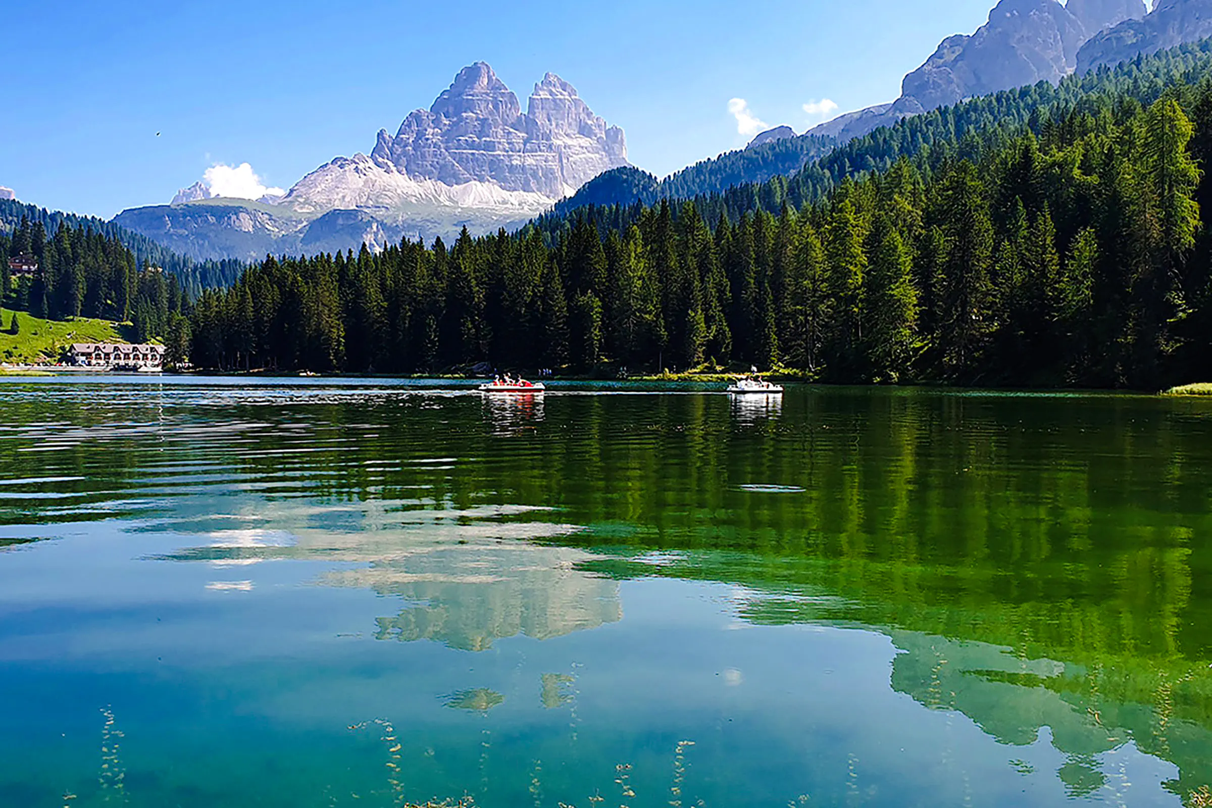 Boats on Lake Misurina with Dolomites in the background, part of a day trip from Venice.