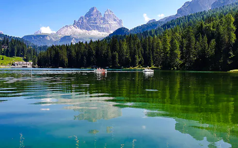 Boats on Lake Misurina with Dolomites in the background, part of a day trip from Venice.