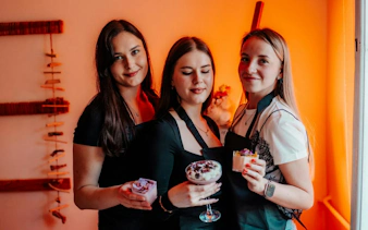 Participants at Krakow candle-making workshop holding scented candles.