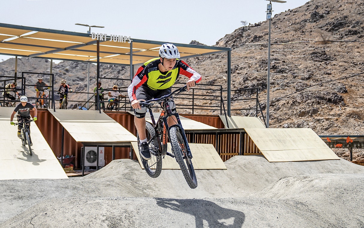 Cyclist jumping on dirt track at Fujairah Adventure Park.