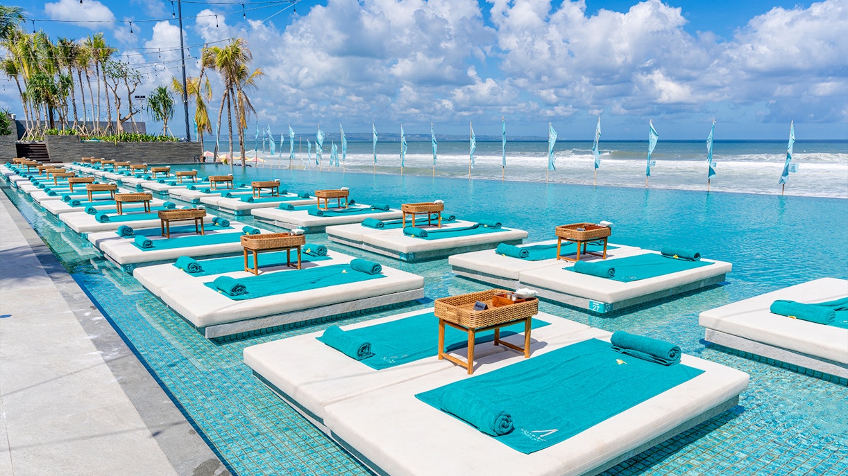 Sun loungers by the pool at Atlas Beach Club with ocean view.