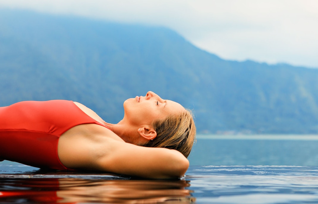 Mount Batur sunrise view with trekkers near Toya Devasya hot spring, Bali.