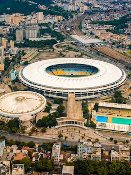 Aerial view of Maracana Stadium in Rio de Janeiro, surrounded by cityscape and nearby buildings.