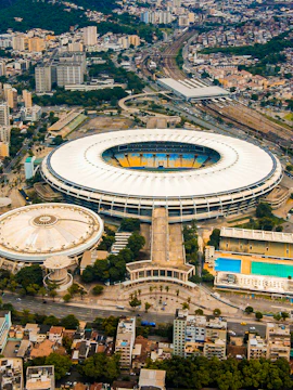 Aerial view of Maracana Stadium in Rio de Janeiro, surrounded by cityscape and nearby buildings.