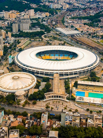 Aerial view of Maracana Stadium in Rio de Janeiro, surrounded by cityscape and nearby buildings.