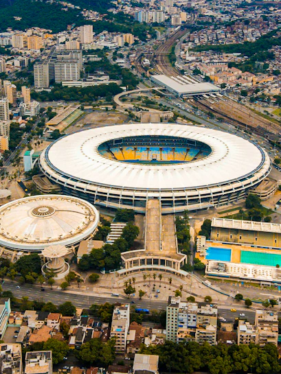 Aerial view of Maracana Stadium in Rio de Janeiro, surrounded by cityscape and nearby buildings.