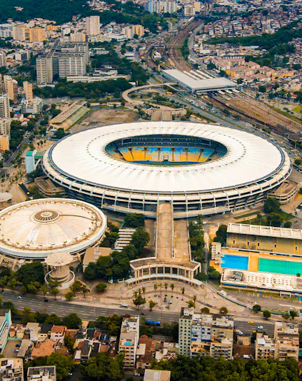 Aerial view of Maracana Stadium in Rio de Janeiro, surrounded by cityscape and nearby buildings.