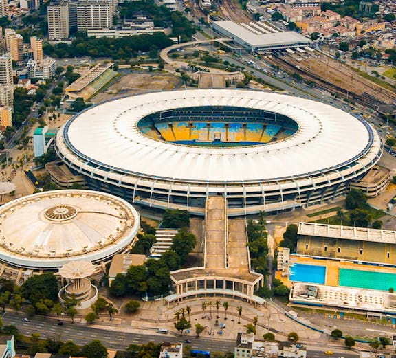 Aerial view of Maracana Stadium in Rio de Janeiro, surrounded by cityscape and nearby buildings.
