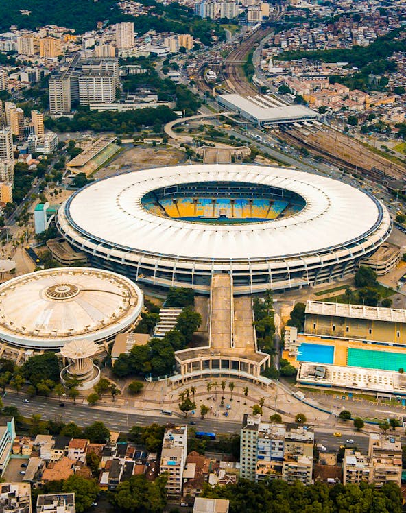 Aerial view of Maracana Stadium in Rio de Janeiro, surrounded by cityscape and nearby buildings.