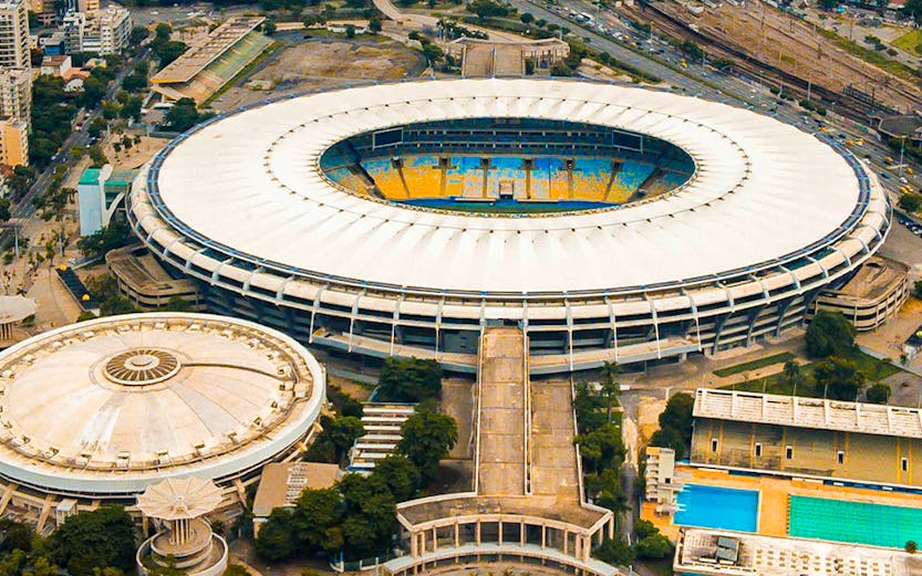Aerial view of Maracana Stadium in Rio de Janeiro, surrounded by cityscape and nearby buildings.