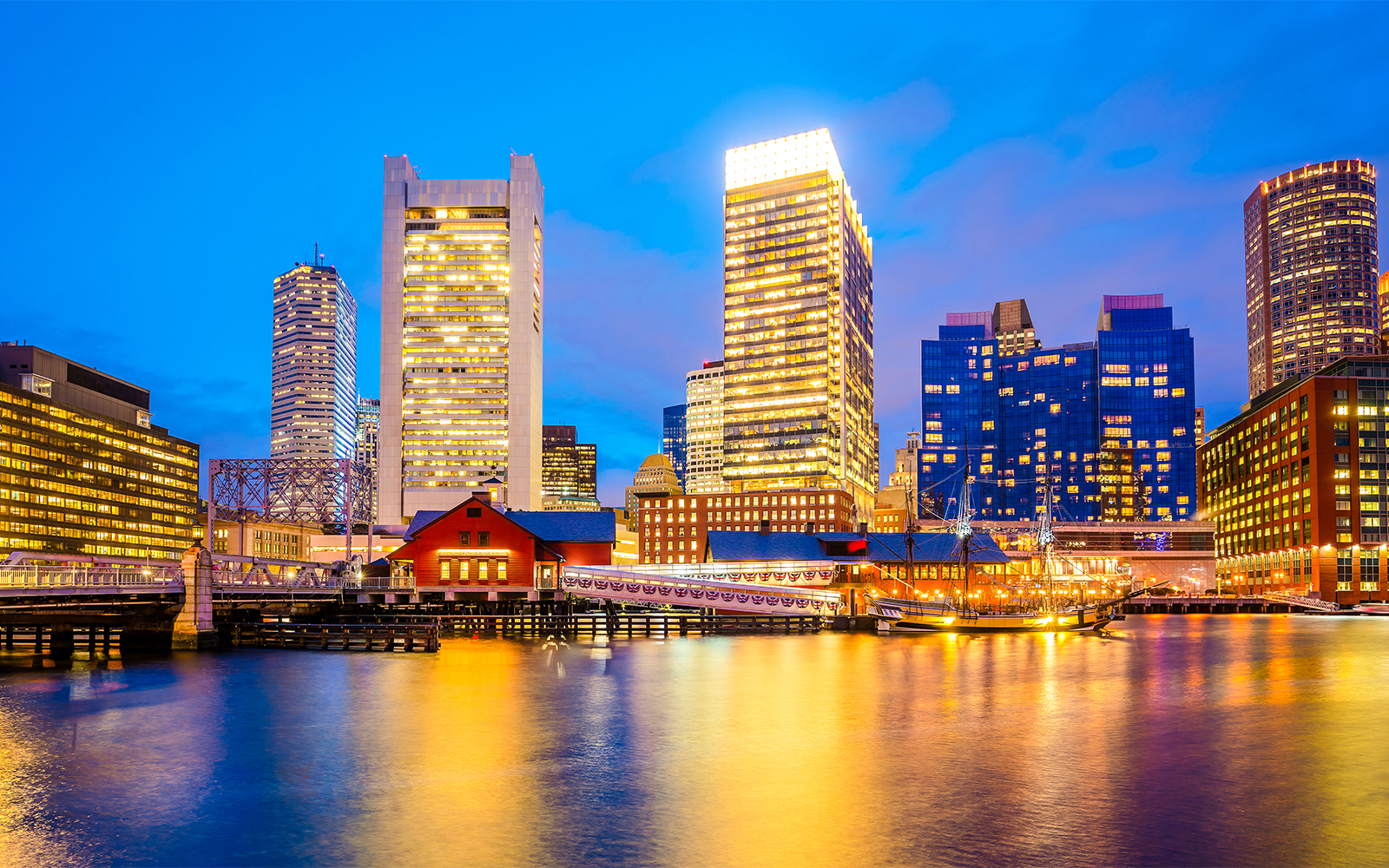 Boston skyline at dusk viewed from a sunset cruise on the harbor.