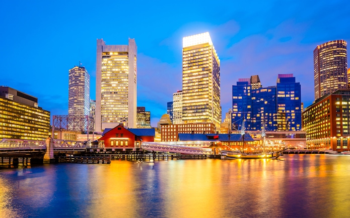 Boston skyline at dusk viewed from a sunset cruise on the harbor.