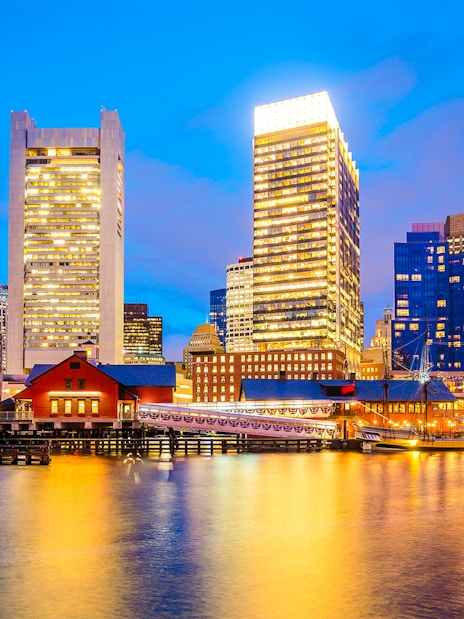 Boston skyline at dusk viewed from a sunset cruise on the harbor.