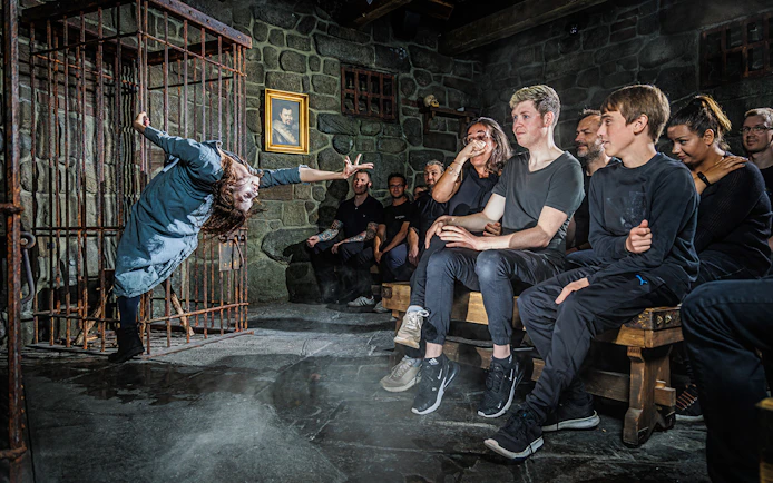 Witch performing in front of an audience inside the Berlin Dungeon.
