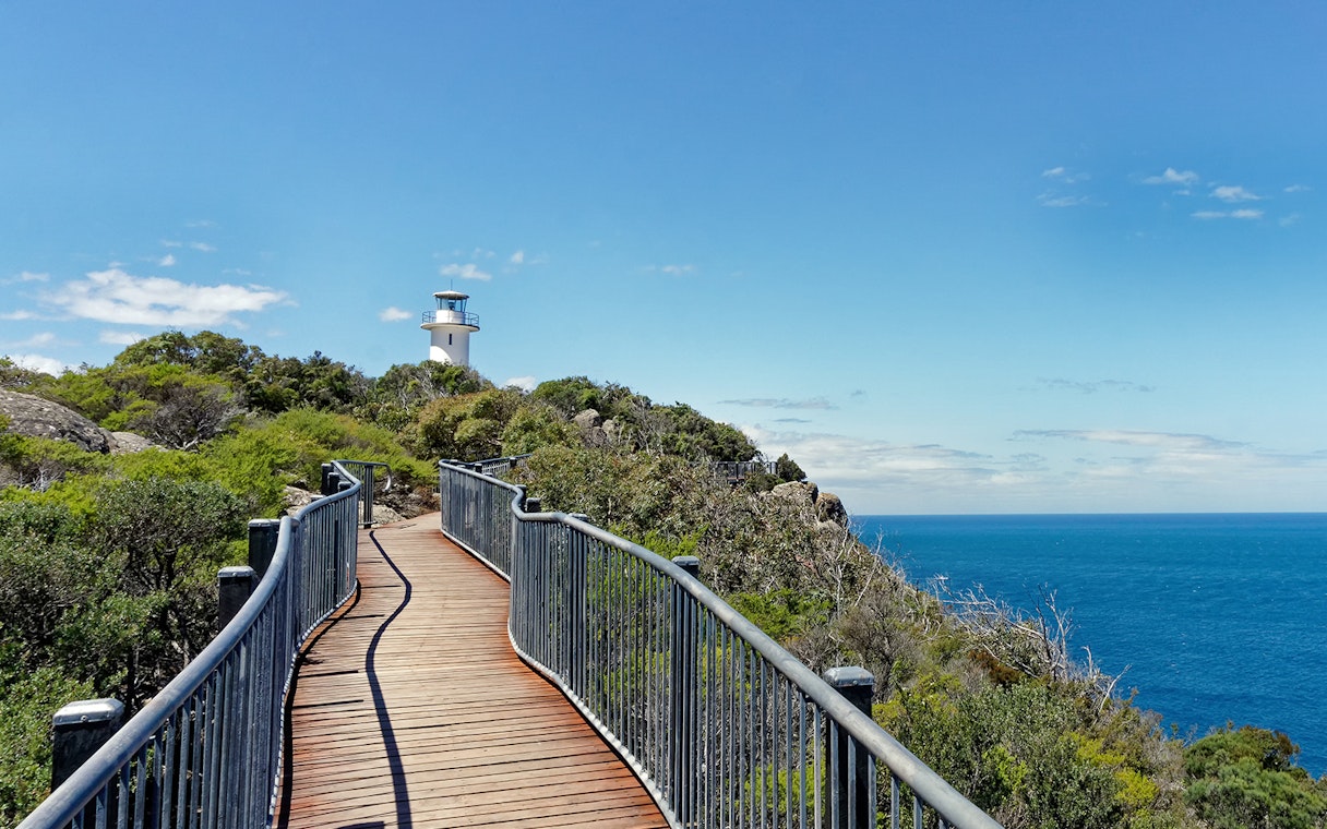 Coastal path leading to a lighthouse near Wineglass Bay, Tasmania.